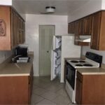 Kitchen with white appliances and wooden cabinets.