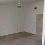 Empty room with ceiling fan and doorway.