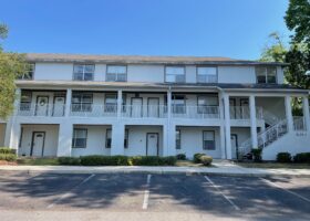 White two-story building with parking lot.