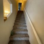 Carpeted stairs leading to an open doorway.