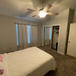 Bedroom with a bed, ceiling fan, and closet.