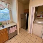 Kitchen with refrigerator, cabinets, and laundry.