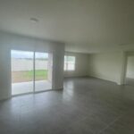 Empty room with tiled floor and sliding doors.