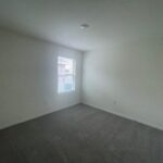 Empty bedroom with carpet and window.