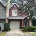 Two-story townhouse with a garage door.