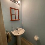 A small bathroom with a sink and mirror.