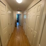 White doors in a hallway with wood floors.