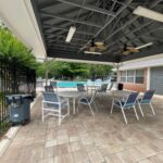 Poolside patio with chairs and tables.