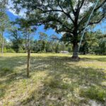 A wooden fence in a grassy field.