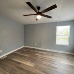 Empty room with ceiling fan and wood floor.