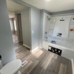 White bathroom with a shower and toilet.