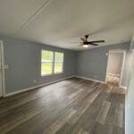 Empty room with wood floor and ceiling fan.