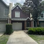 Two houses with garages and green landscaping.