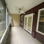 Screened-in porch with tile floor and ceiling fan.