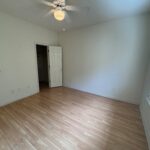 Empty room with hardwood floor and window.