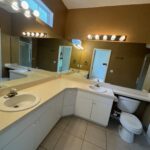 A white bathroom with double sinks.