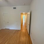 Empty room with hardwood floors and doors.