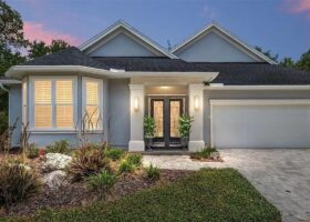 Gray house with black double doors and a garage.
