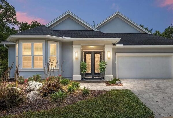 Gray house with black double doors and a garage.