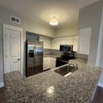 Kitchen with granite countertop and stainless steel appliances.