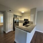 Modern kitchen with granite countertops and stainless steel appliances.
