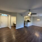 Empty living room with hardwood floors.