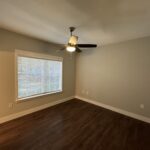 Empty room with wood floor and fan.