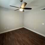 Empty room with ceiling fan and hardwood floor.