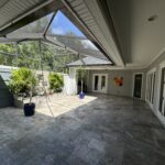 Stone patio with glass doors and plants.