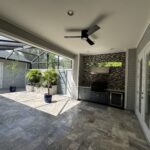Outdoor kitchen with patio and ceiling fan.