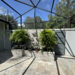 Stone patio with potted plants and water feature.