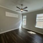Empty room with ceiling fan and wood floor.