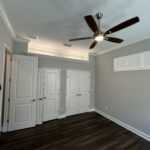 Empty room with ceiling fan and doors.