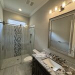 Modern bathroom with shower, toilet, and sink.