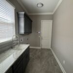 Modern laundry room with sink and cabinets.
