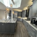 Modern kitchen with gray cabinets and granite countertop.