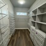 White closet with wire shelves and drawers.