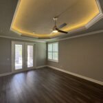 Empty room with hardwood floors and ceiling fan.
