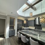 Modern kitchen with granite countertop and bar stools.