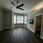 Empty living room with dark wood floors.
