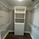 White closet with shelves and drawers.