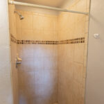 Tiled shower stall with shower head.