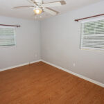 Empty room with wood floor and ceiling fan.