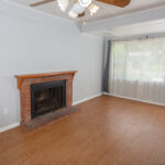 Empty living room with fireplace and curtains.