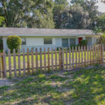 White house with picket fence and green grass.