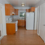 Kitchen with wood cabinets and white appliances.