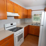 White kitchen with wood cabinets and appliances.