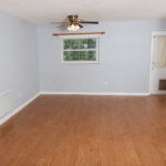 Empty room with wood floor and ceiling fan.