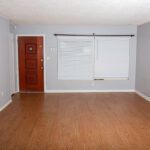 Empty room with wood floor and blinds.