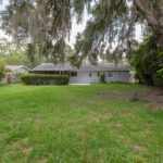 Backyard view of a house with Spanish moss.